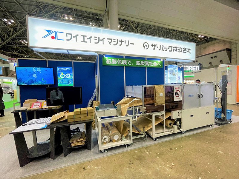 TOKYO PACK 2022におけるワイエイシイマシナリー株式会社様とザ・パックの共同出展ブース。紙製宅配袋 自動包装システムやEC市場向けパッケージを紹介している。