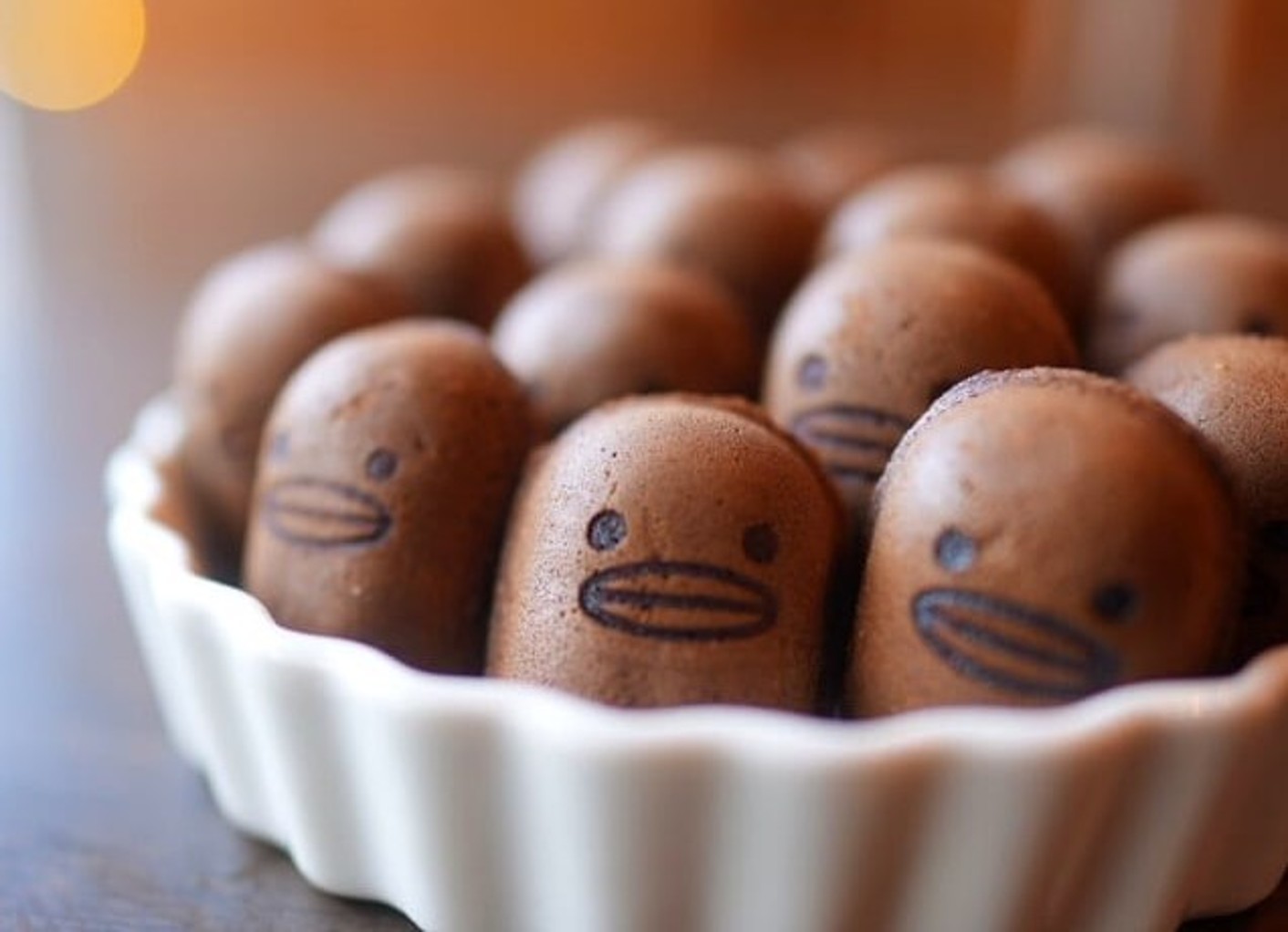 皿に並んだ、顔が描かれた小さな焼き菓子のクローズアップ